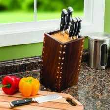 wood knife block with knives sitting on top of a granite countertop