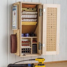 open sanding supply cabinet with sanding supplies hanging on a wall